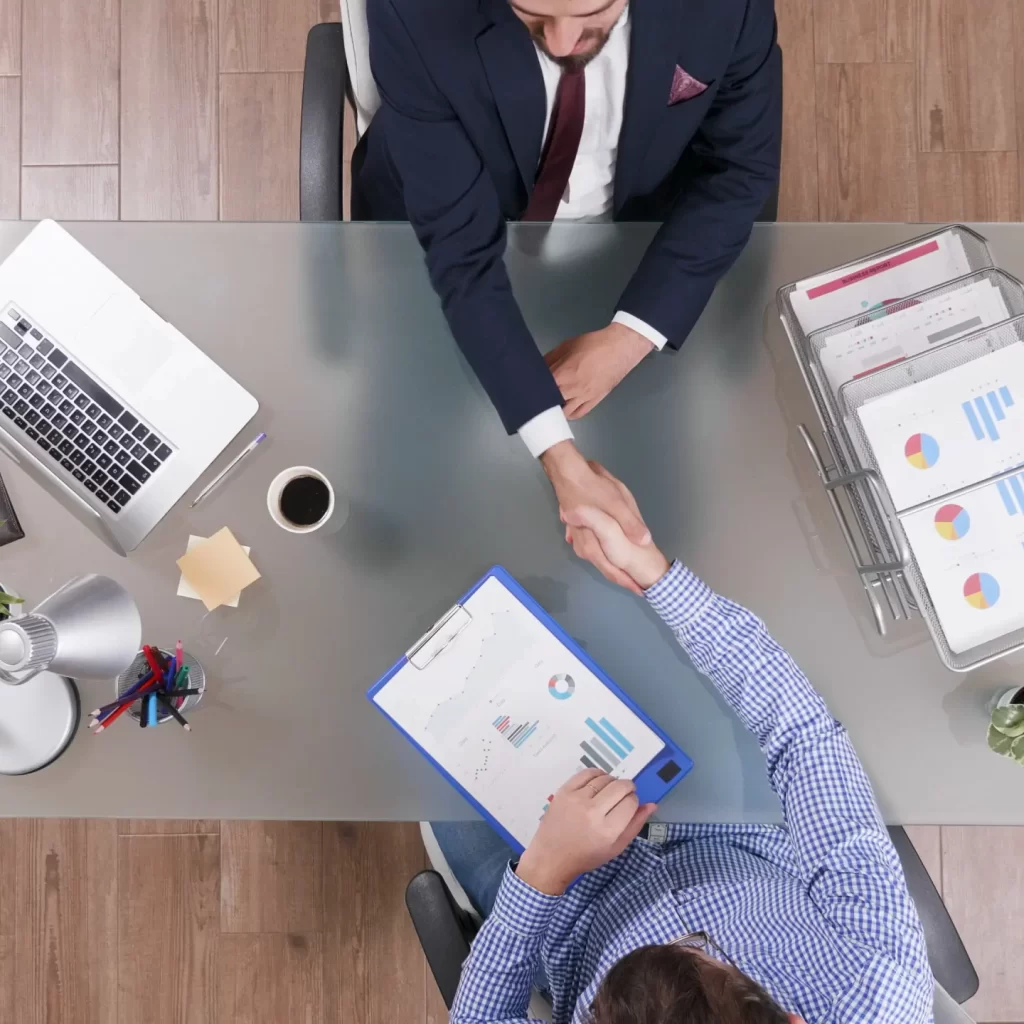 top-view-businessmen-shaking-hands-business-negotiation-startup-office